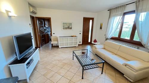 een woonkamer met een bank en een tv bij Casa Piera in Pietrasanta