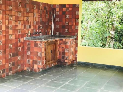 uma cozinha exterior numa casa com uma parede de tijolos em Pousada 1800 Altitude Monte Verde em Monte Verde
