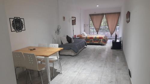 uma sala de estar com uma mesa e um sofá em Amplio departamento completo en Caba em Buenos Aires