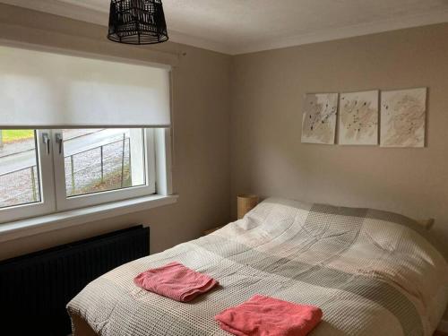 a bedroom with a bed with two pink towels on it at Monthly/ weekly discounts, lovey apartment! in Clydebank