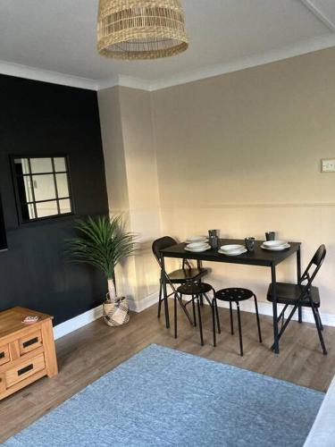 a dining room with a table and chairs in a room at Budget friendly apartment with stairs Near Glasgow airport and Loch Lomond in Clydebank