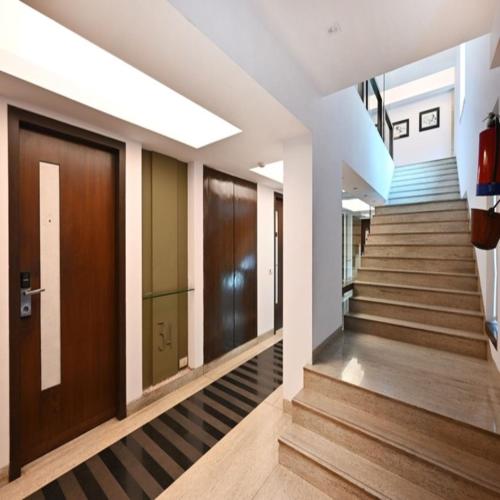 a hallway of a building with wooden doors and stairs at The Legend Hotel- Santacruz Near Mumbai International Airport in Mumbai