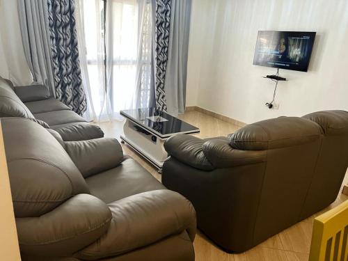 a living room with a couch and a table at Beautiful family House in Kasiyirize