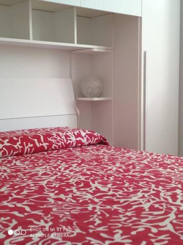 a bedroom with a bed with a red and white bedspread at Casa Cappero in Noto Marina