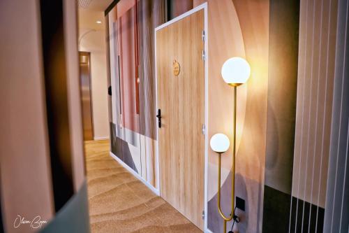 a hallway with two lights next to a door at Mercure Dunkerque Centre Gare in Dunkerque