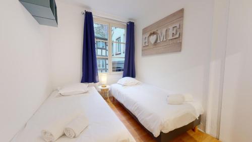 deux lits dans une chambre avec une fenêtre dans l'établissement Magda & Lena Strasbourg city center Bail Mobilité, à Strasbourg