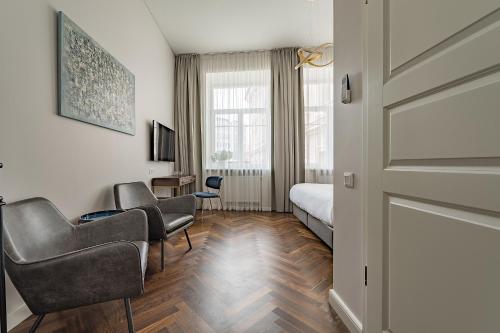 une chambre d'hôtel avec un lit et deux chaises dans l'établissement GRAND CROWN, à Vilnius