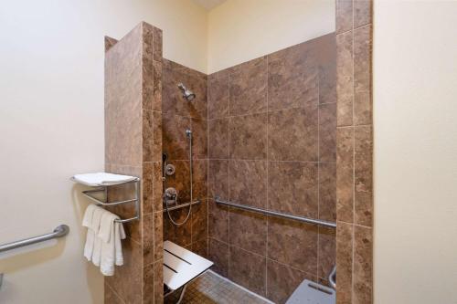 een badkamer met een douche en een glazen deur bij Baymont by Wyndham Savannah South in Savannah