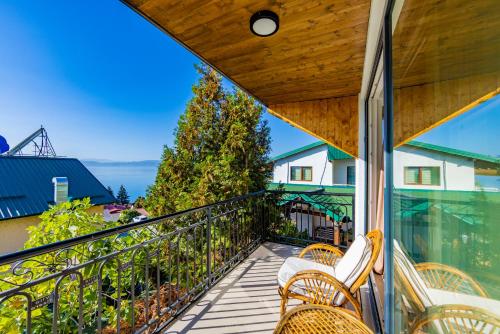 a balcony with chairs and a view of the ocean at Vila Bisera in Ohrid