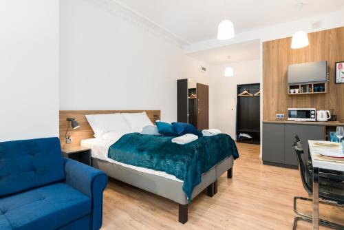 sypialnia z łóżkiem i niebieską kanapą w obiekcie Kwiatowa Apartments Poznań City Center by Noclegi Renters w Poznaniu