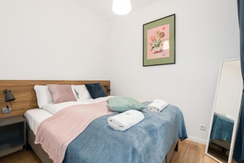 a bedroom with a bed with towels on it at Kwiatowa Apartments Poznań City Center by Renters in Poznań
