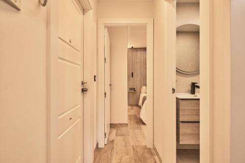 a hallway leading to a bathroom with a sink at Little Sopranis Little Apartments in Cádiz