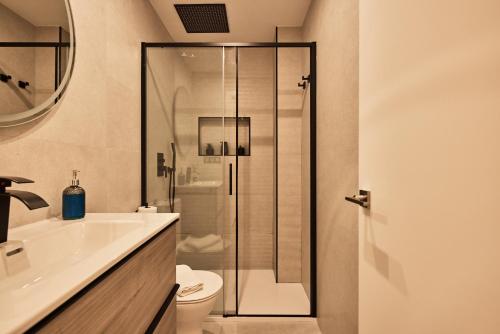 a bathroom with a shower and a toilet and a sink at Little Sopranis Little Apartments in Cádiz