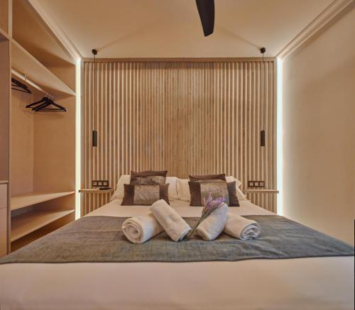 a bedroom with a large bed with two pillows at Little Sopranis Little Apartments in Cádiz