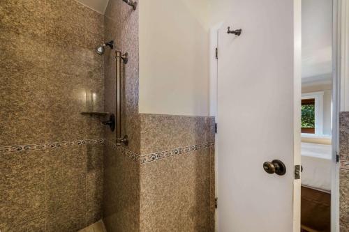 a bathroom with a walk in shower next to a door at Clarion Collection Carmel Oaks Inn in Carmel