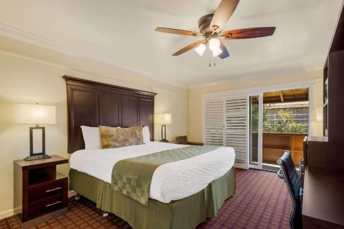 a bedroom with a bed and a ceiling fan at Clarion Collection Carmel Oaks Inn in Carmel