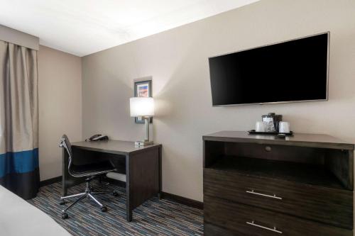 a hotel room with a desk and a television at Comfort Inn & Suites Near Medical Center in San Antonio