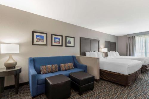 Habitación de hotel con cama y sofá azul en Comfort Inn & Suites Near Medical Center, en San Antonio