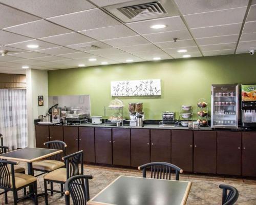 a restaurant with a counter with tables and chairs at Sleep Inn & Suites Pineville - Alexandria in Pineville