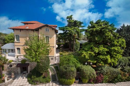 ein Luftblick auf ein Haus mit Bäumen und Sträuchern in der Unterkunft Hotel Villa Maria in Desenzano del Garda