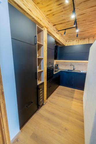 a kitchen with blue cabinets and a wooden ceiling at Hillside Chalet Kreischberg in Sankt Lorenzen ob Murau