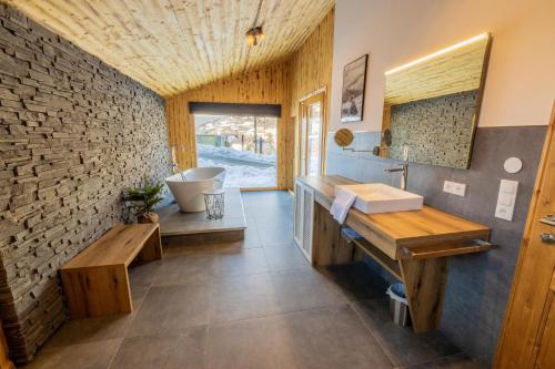 a bathroom with a sink and a stone wall at Hillside Chalet Kreischberg in Sankt Lorenzen ob Murau