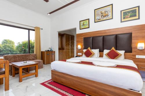 a hotel room with a large bed and a couch at Seven Corbett in Rāmnagar