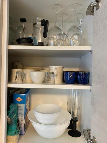 a pantry filled with bowls and other kitchen items at Lovely Studio in Kallio in Helsinki