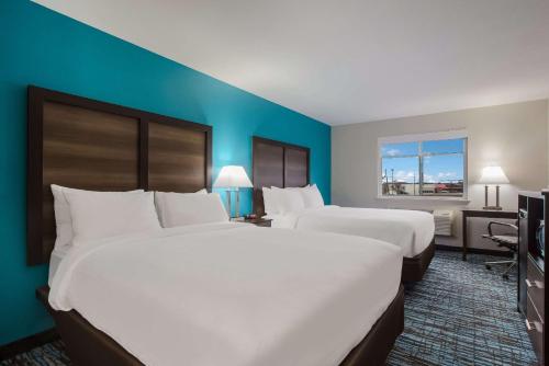 duas camas num quarto de hotel com paredes azuis em Clarion Pointe Harrodsburg-Danville em Harrodsburg