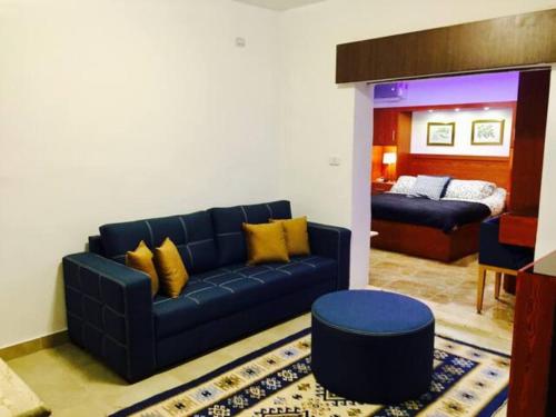 un soggiorno con divano blu e letto di The Royal Luxury Lion Patio ad Amman