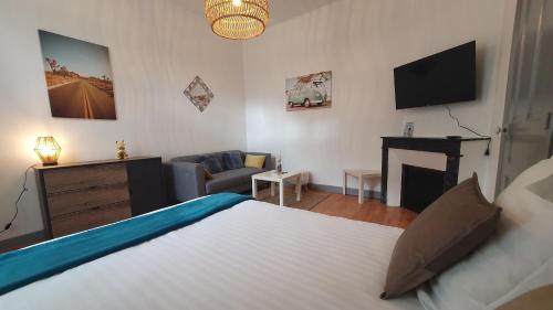 sypialnia z łóżkiem oraz salon z telewizorem w obiekcie Bel appartement en centre-ville avec terrasse w mieście Pau