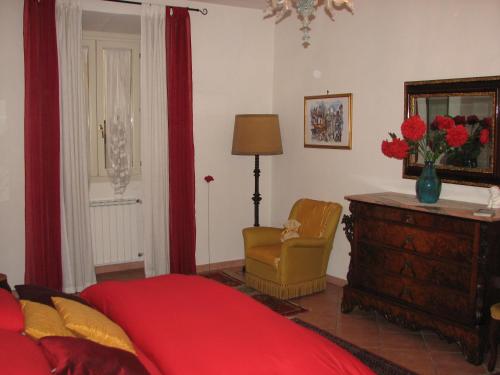 a bedroom with a bed and a chair and a dresser at B&B Fiordaliso in Florence