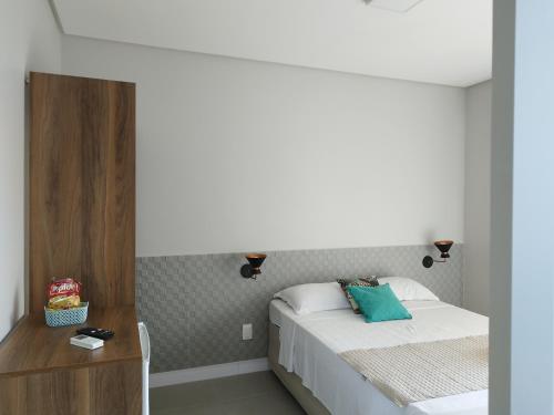 a small bedroom with a bed and a night stand at Bless in Maragogi