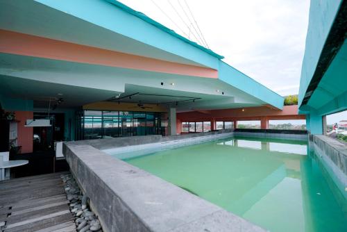 a swimming pool in front of a building at Sans Sunset Point Seminyak in Seminyak