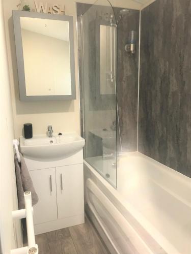 a bathroom with a shower and a sink and a tub at Cumbria Reach in Longtown