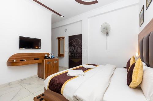 a bedroom with a bed and a tv on a wall at Seven Corbett in Rāmnagar