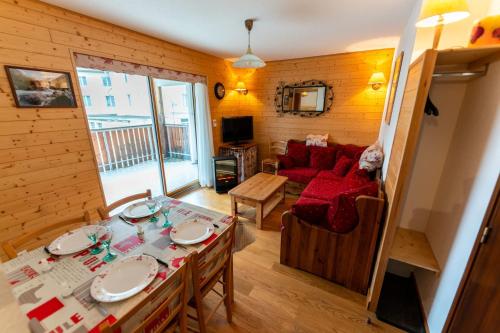 salon z czerwoną kanapą i stołem w obiekcie Warm 29m with balcony and lake view w mieście Gérardmer
