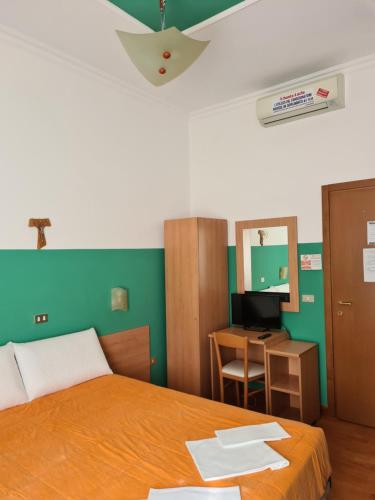 a bedroom with a bed and a desk with a computer at B&B Santa Lucia in San Giovanni Rotondo