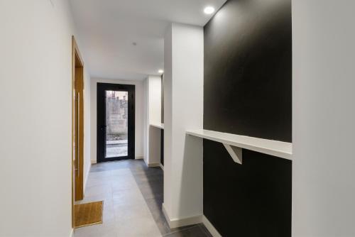 a hallway with a large flat screen tv on a wall at Apartamentos La muralla de Jaca in Jaca