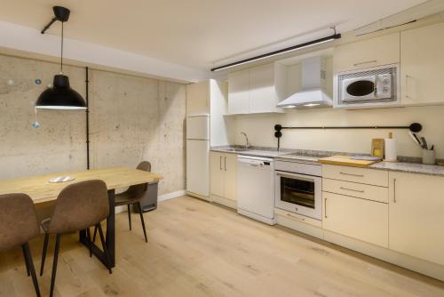 a kitchen with a wooden table and a dining room at Apartamentos La muralla de Jaca in Jaca