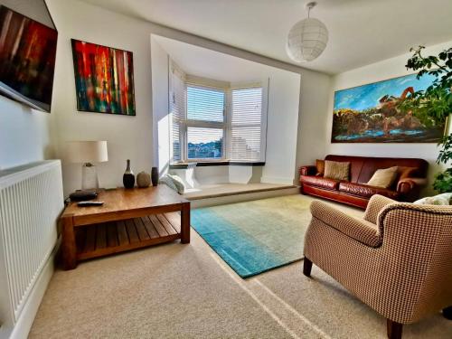 a living room with a couch and a table at Seashells at 2 TRENCROM COURT ST IVES in Carbis Bay