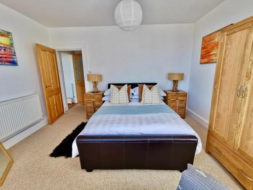 um quarto com uma cama grande e duas mesas de cabeceira em Seashells at 2 TRENCROM COURT ST IVES em Carbis Bay