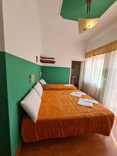 a bedroom with two beds and a green wall at B&B Santa Lucia in San Giovanni Rotondo