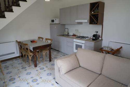 sala de estar con sofá, mesa y cocina en B&B Il borgo incantato, en Laureana Cilento