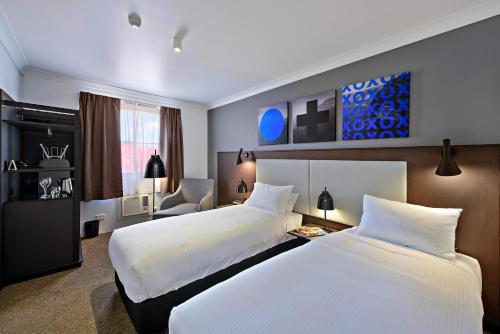 Postel nebo postele na pokoji v ubytování CKS Sydney Airport Hotel