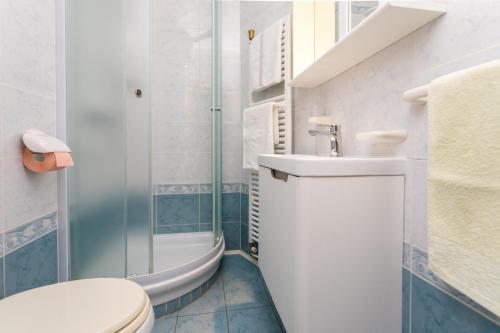 uma casa de banho com um WC, um lavatório e um chuveiro em Apartments Dinka Vantačići em Malinska