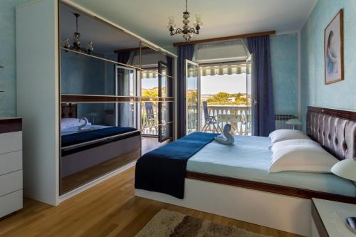 a bedroom with a bed and a balcony at Apartments Dinka Vantačići in Malinska
