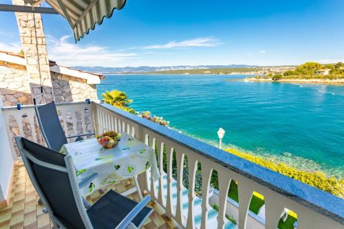a balcony with a table and a view of the water at Apartments Dinka Vantačići in Malinska