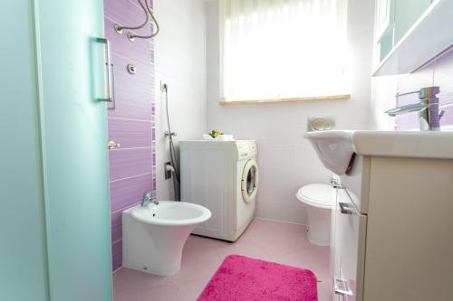 a bathroom with a white toilet and a sink at Apartments Dinka Vantačići in Malinska