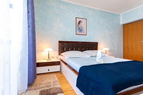 a bedroom with a bed and two night stands and two lamps at Apartments Dinka Vantačići in Malinska